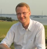 Kenneth siddende p&aring; &Oslash;rnestenbjerget i Sydbyen, med h&oslash;jsp&aelig;ndingsmasterne i baggrunden. Foto: Preben G&oslash;ttsche.